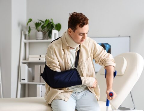 Young man with arm sling and crutch after filing a premises liability claim in Brooklyn NY