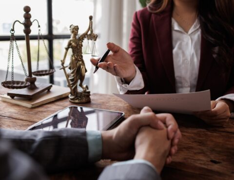 Personal injury claim after death consultation with an attorney reviewing legal documents and scales of justice