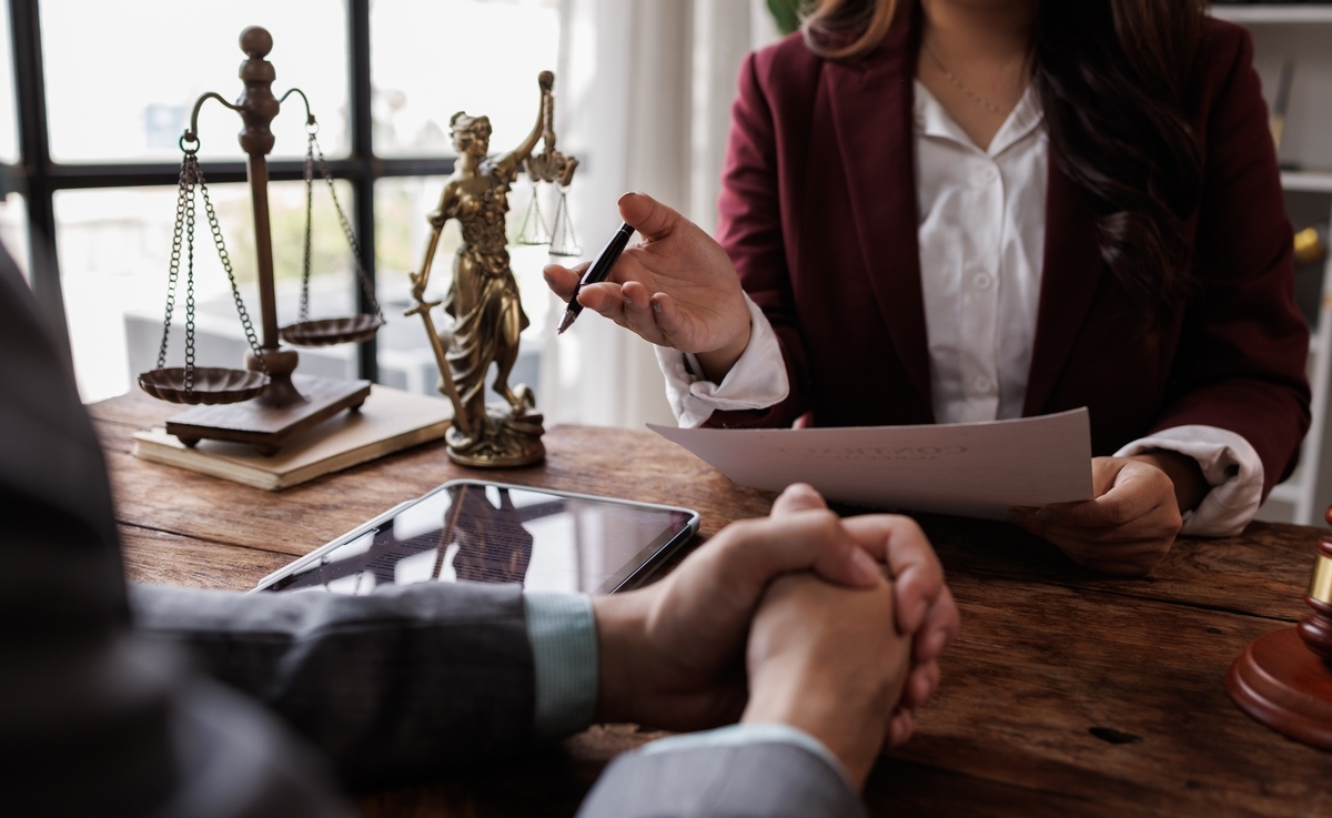 Personal injury claim after death consultation with an attorney reviewing legal documents and scales of justice