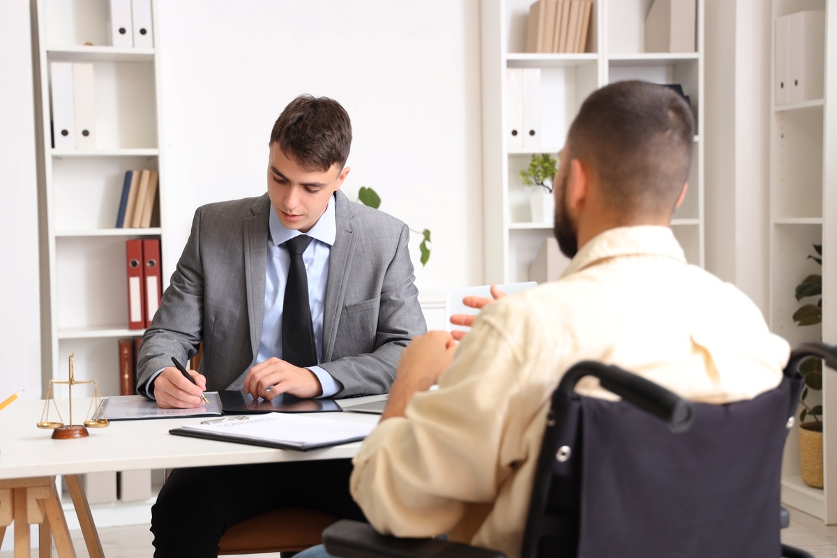 Personal injury lawyer in the Bronx NY consulting with an injured client in a wheelchair during a legal consultation