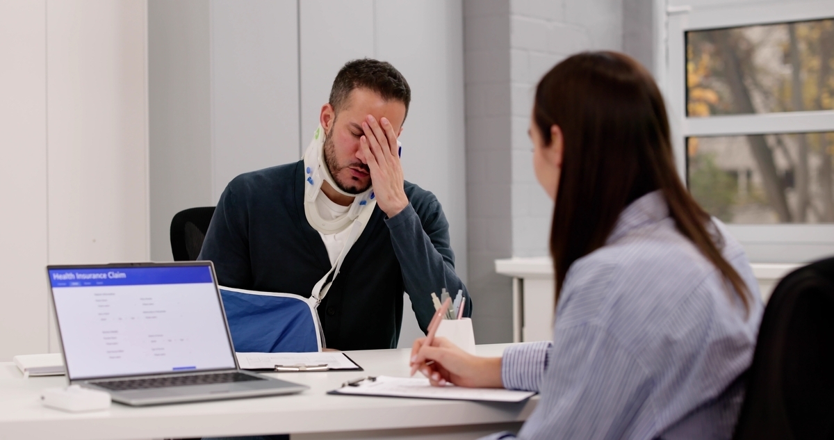 Personal injury lawyer in Staten Island NY consulting with an injured client wearing a neck brace and arm sling