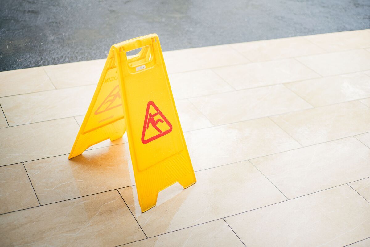 Yellow caution wet floor sign illustrating slip and fall notice in NY cases