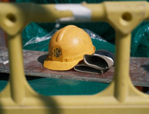 Hard hat and work gloves set aside at a job site, representing a work injury claim in NY