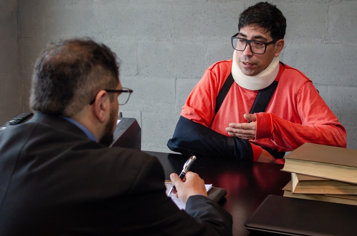 Motorcycle accident lawyer in Trenton NJ consulting with an injured client in a neck brace and arm sling
